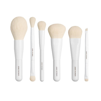 Eight travel-sized makeup brushes with white cream bristles
