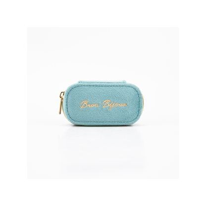 A small light blue felt pouch with gold zipper trim and gold embroidered script reading 'Brux Bijoux' on the front, shown on a clean white background.