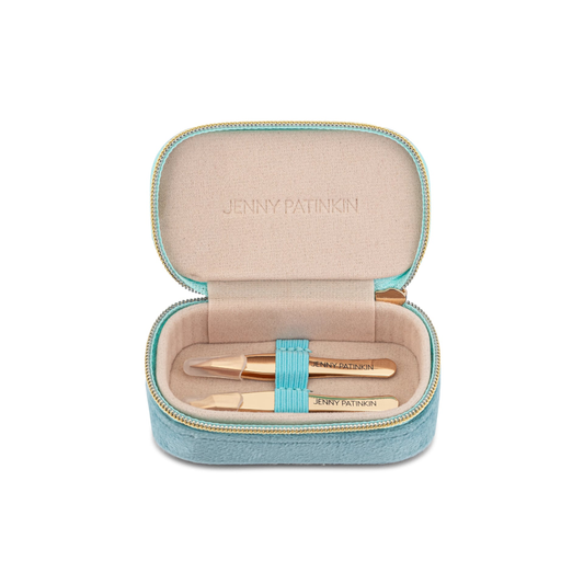 An open light blue zippered case with a beige interior, containing two gold cosmetic tools and a turquoise elastic band. The brand name 'JENNY PATNIKON' is embossed on the inner lid and printed on the tools.