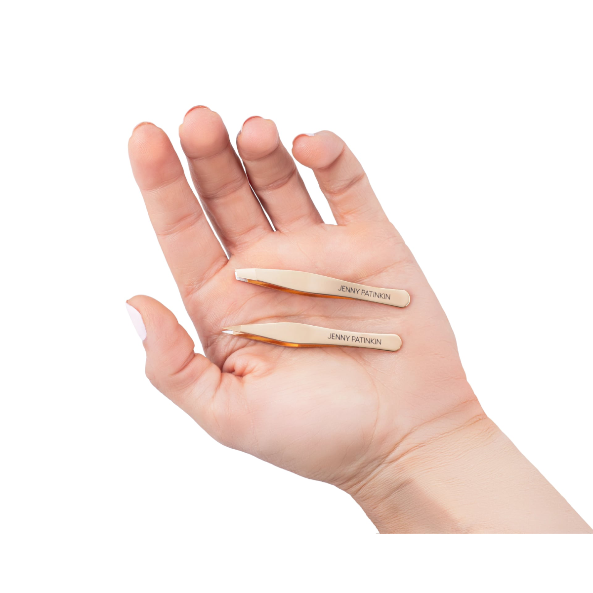 Two small beige tweezers engraved with the brand name 'JENNY FAYTHORNE' resting on an open hand against a plain white background.